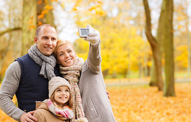 Image showing happy family with camera in autumn park