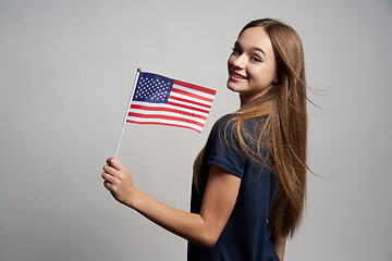 Image showing Happy female holding USA flag