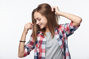 Image showing Smiling relaxed teen girl with raised hands looking down,