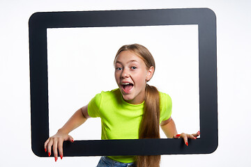 Image showing Happy teen girl peeking through digital tablet frame