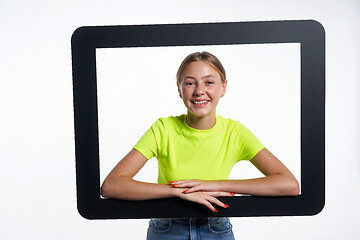 Image showing Smiling teen girl looking through digital tablet frame