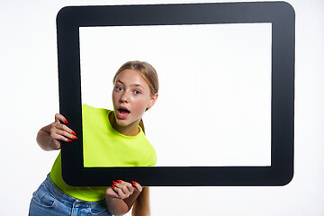 Image showing Teen girl peeking through digital tablet frame