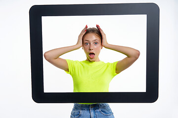 Image showing Teen girl peeking through digital tablet frame