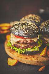 Image showing Black double Burgers with Cheese. Cheeseburgers from Japan with black bun on dark background