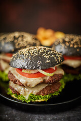 Image showing Black double cheeseburger with tomatoes and lettuce