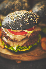 Image showing Black double Burgers with Cheese. Cheeseburgers from Japan with black bun on dark background