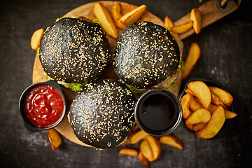 Image showing Black burgers and fries with sauce