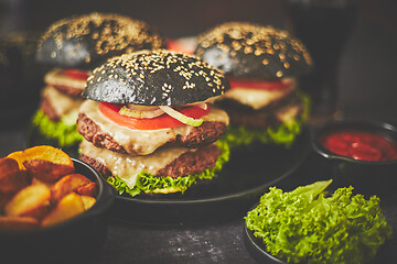 Image showing Appetizing black hamburgers and fried potato