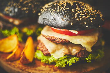 Image showing Delectable black hamburger and potato chips