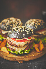 Image showing Black double Burgers with Cheese. Cheeseburgers from Japan with black bun on dark background