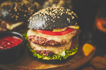 Image showing Black double Burgers with Cheese. Cheeseburgers from Japan with black bun on dark background