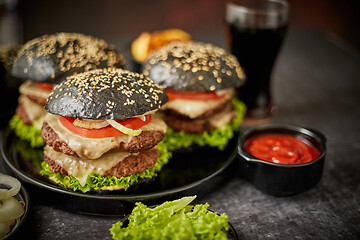 Image showing Appetizing black hamburgers and fried potato