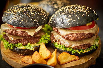 Image showing Appetizing black hamburgers and fried potato