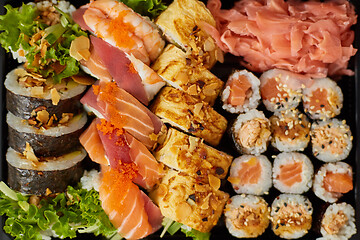 Image showing Close up of Various sushi set in black plastic delivery box. Top view