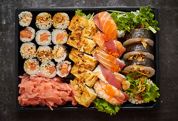 Image showing Close up of Various sushi set in black plastic delivery box. Top view