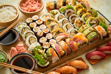 Image showing Above view of various sushi and rolls placed on wooden board. Japanese food fest