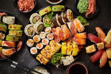 Image showing Asian food fest. Menu sushi with nigiri, maki, uramaki on black plates. Various kinds of sushi