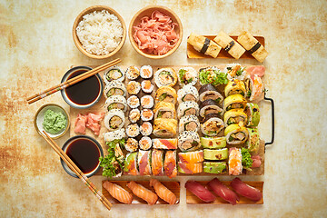 Image showing Top view background with set of colorful different kinds of sushi rolls placed on wooden board