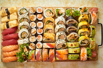 Image showing Above view of various sushi and rolls placed on wooden board. Japanese food fest