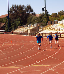 Image showing three young girls running on track sprinting competition