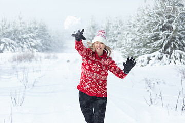 Image showing Playful woman throwing a snowball