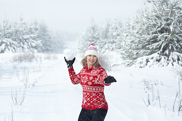 Image showing Happy woman throwing a large snowball in winter