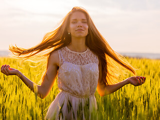 Image showing Girl with flowing hair backlit by sunset