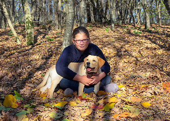 Image showing Portrait of girl with dog in autumn forest
