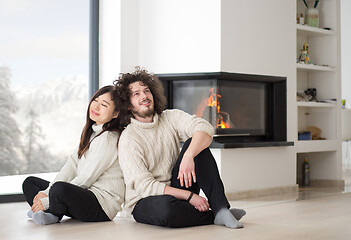 Image showing happy multiethnic couple  in front of fireplace