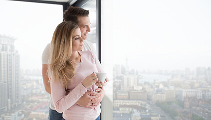 Image showing young couple enjoying morning coffee by the window