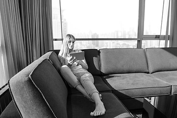 Image showing young woman on sofa at home surfing web