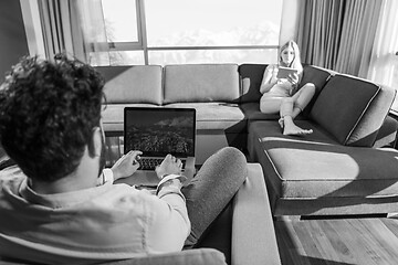 Image showing couple relaxing at  home using tablet and laptop computers