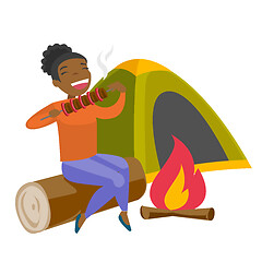 Image showing Woman sitting on log near campfire in the camping.