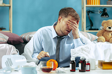 Image showing Bearded sick man with flue sitting on sofa at home. Illness, influenza, pain concept. Relaxation at Home. Healthcare Concepts.