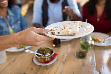 Image showing international friends eating at restaurant