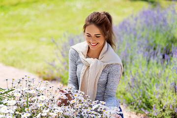 Image showing young woman with flowers at summer garden