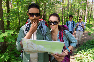 Image showing friends with map and backpacks hiking in forest