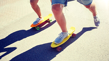 Image showing teenage couple riding skateboards on city road