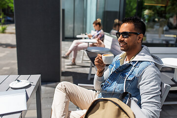 Image showing indian man drinking coffee at city street cafe