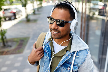 Image showing indian man in headphones with backpack in city