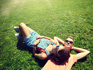 Image showing happy teenage couple lying on grass at summer