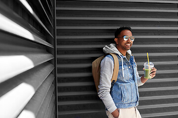 Image showing man with backpack drinking smoothie on street