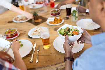 Image showing international friends eating at restaurant