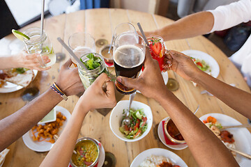 Image showing friends eating and clinking glasses at restaurant