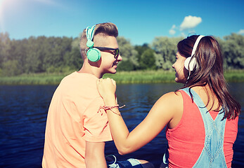 Image showing teenage couple with headphones on river berth