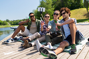 Image showing friends with drinks taking selfie on lake pier