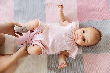 Image showing baby girl lying on blanket and mother\'s hands