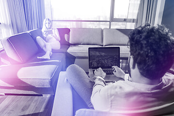 Image showing couple relaxing at  home using tablet and laptop computers