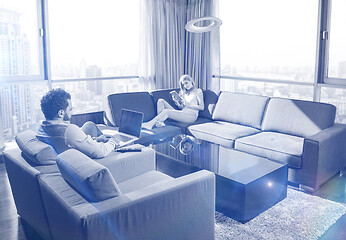 Image showing couple relaxing at  home using tablet and laptop computers