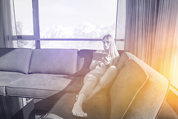 Image showing young woman on sofa at home surfing web